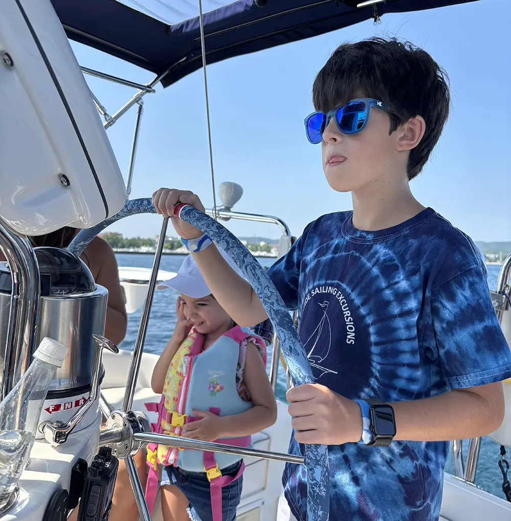 Young boy at helm of the Impulse on Grand Traverse Bay in Traverse City Michigan