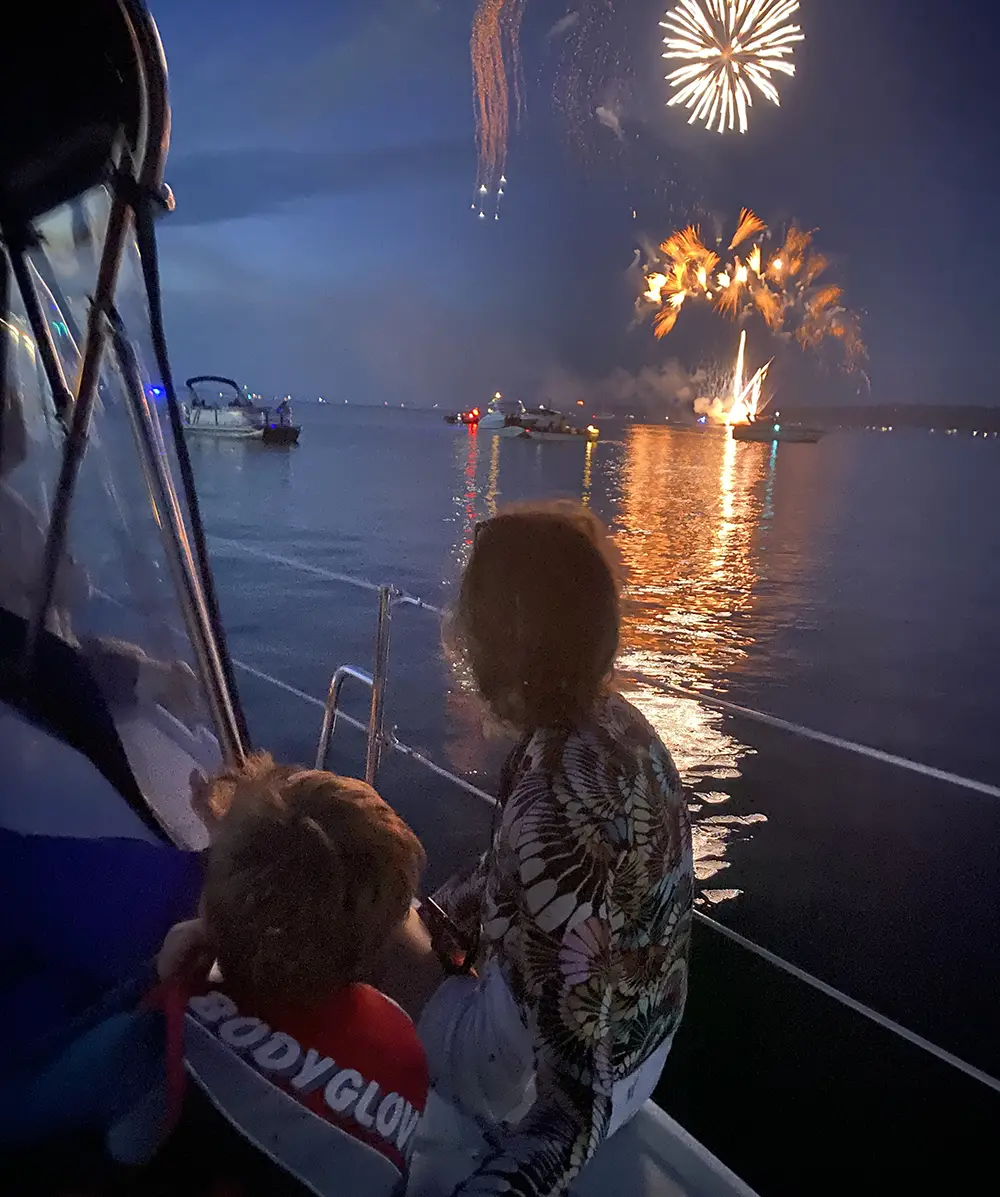 Family enjoying fireworks over Grand Traverse Bay while sailing 