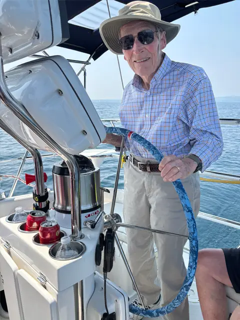 A 90 year old man enjoys helming the Impulse while sailing in Traverse City Michigan
